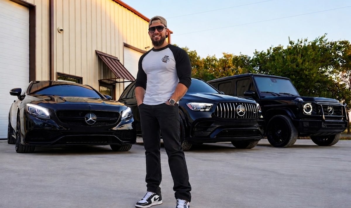The founder of Airborne Dent Repair standing outside the shop in front of three black Mercedes-AMG vehicles